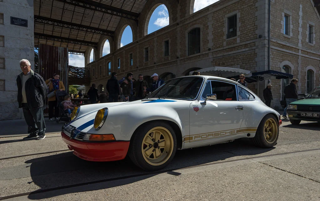 Porsche 911: A low sports car with a sloping roofline, rounded lamps, long rear deck, and compact cabin.